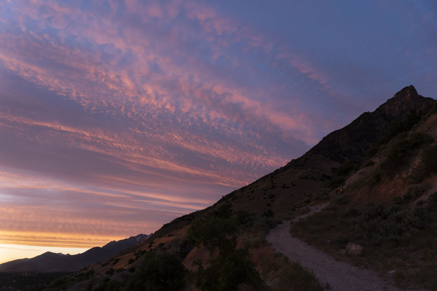 A streaky and textured and banded sunset reminiscent of some gaseous planet's atmosphere behind the mountain